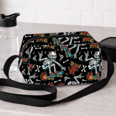 Bolsa tiracolo com padrão de esqueletos a andar de skate e diabretes vermelhos sobre fundo preto