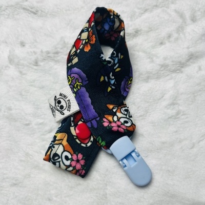 Prendedor de chupeta com padrão colorido e fecho de plástico azul