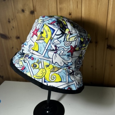 Chapéu pescador branco com padrão colorido e aba preta em suporte negro