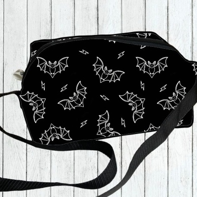 Bolsa preta com padrão de morcegos e raios em branco e alça preta