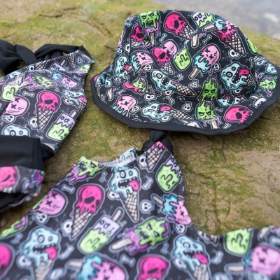 Roupa de banho e chapéu com desenhos coloridos de gelados e caveiras em fundo preto