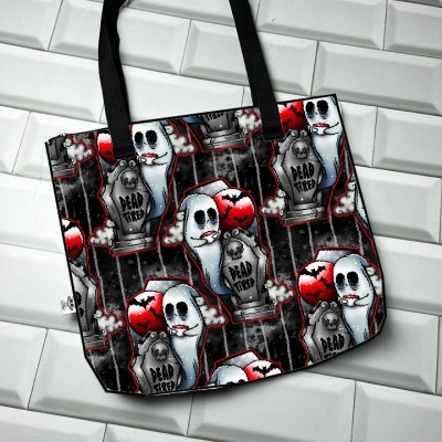 Saco de tecido com padrão de fantasmas, lápides e morcegos sobre fundo escuro