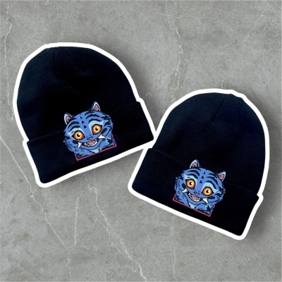 Dois gorros pretos com emblema de rosto de gato azul colorido.