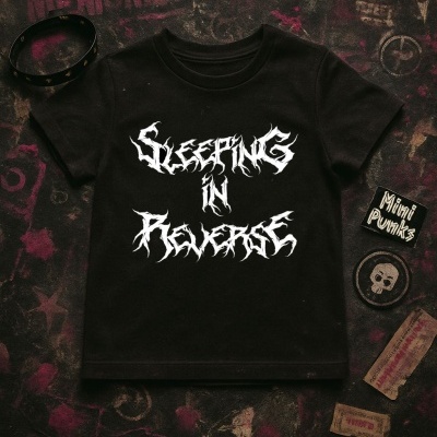 T-shirt preta com texto branco estilizado e acessórios sobre superfície escura com estampas.