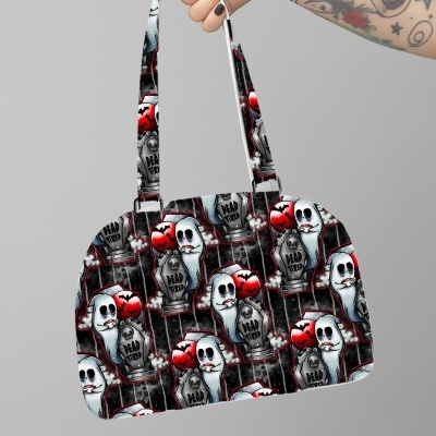 Saco de mão com padrão de fantasmas, corações e lápides, mão segurando com tatuagens e unhas pretas
