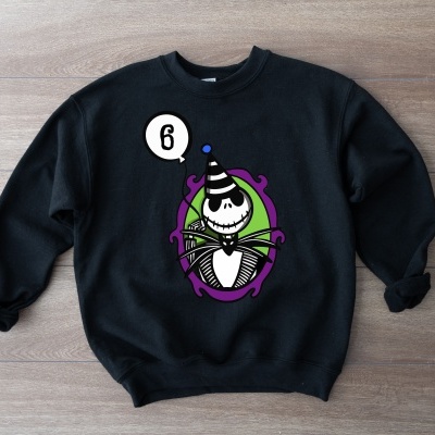 Sweatshirt preta com estampa colorida de personagem em oval roxo e verde