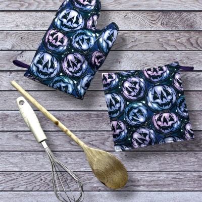 Conjunto de luva e pega-luvas de cozinha com padrão de Halloween e utensílios de cozinha sobre madeira
