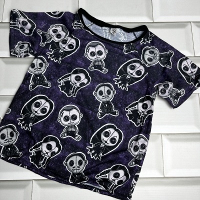 T-shirt infantil escura com padrão de personagens em fundo branco de azulejos