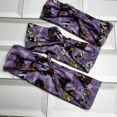 Três faixas elásticas roxas com padrão de rostos femininos coloridos sobre azulejos brancos