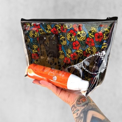 Necessaire transparente com máscara, frasco laranja e óculos de sol