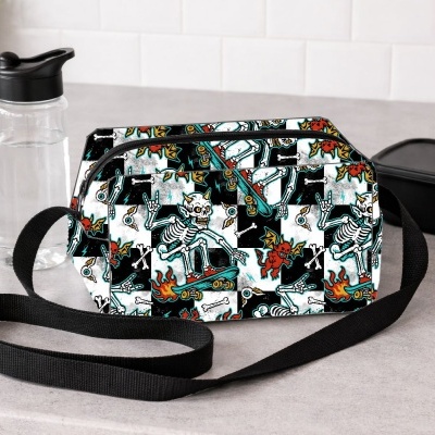 Bolsa com padrão colorido de esqueletos e criaturas em fundo preto e branco.