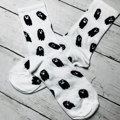 Meias brancas com padrão de fantasmas pretos sobre madeira branca
