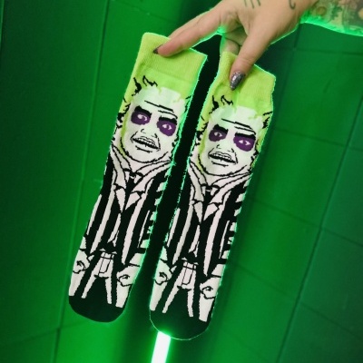 Meias estampadas com rosto e cabelo verde-limão em fundo verde neon