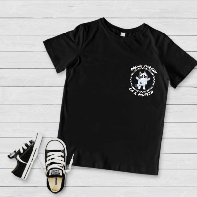 T-shirt preta com estampa branca e sapatilhas pretas e brancas sobre fundo de madeira clara