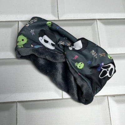 Faixa preta com estampado de máscaras e aliens verdes sobre azulejos brancos