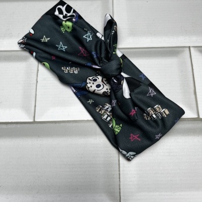 Faixa de cabelo preta com padrão colorido sobre azulejos brancos