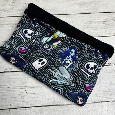Bolsa estampada preta com desenhos de caveiras e personagens em estilo cartoon