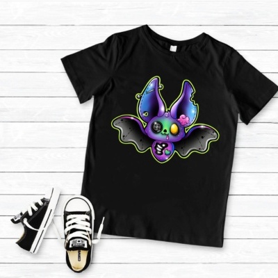 T-shirt preta com estampa de morcego colorido e ténis pretos sobre tábuas de madeira claras