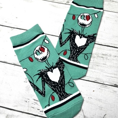 Meias verdes com desenho de personagem esquelético e luzes coloridas