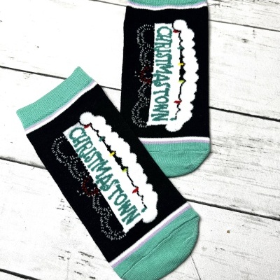 Par de meias pretas com detalhes verdes e palavras Christmas Town