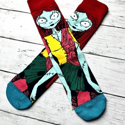 Meias coloridas com estampa de personagem de cartoon sobre fundo de tábuas brancas