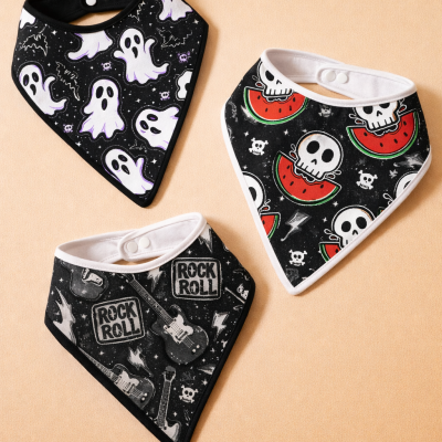 Três babetes de tecido com padrão preto e desenhos brancos e vermelhos