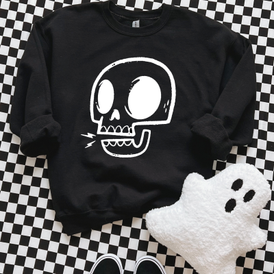 Sweatshirt preta com estampa de crânio branco sobre padrão xadrez com almofada de fantasma e sapatilhas