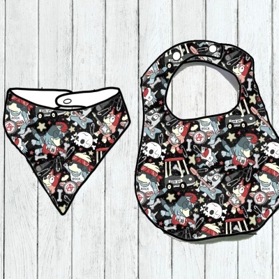 Conjunto de dois babetes infantis com padrão colorido sobre fundo de madeira branca