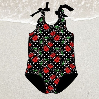 Fato de banho colorido para criança com padrão floral sobre areia