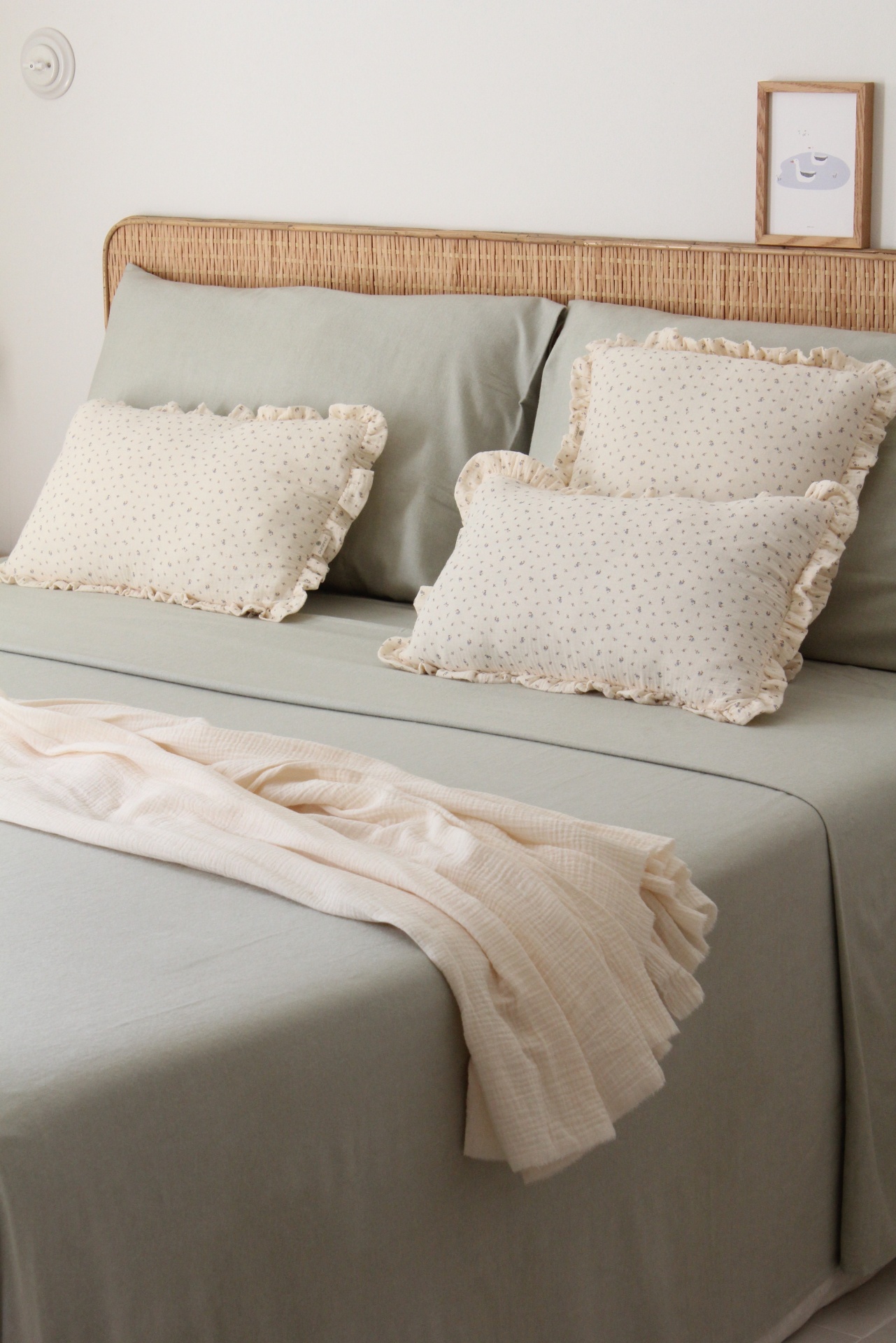 Cama com almofadas decorativas e cobertor branco, cabeceira de madeira clara