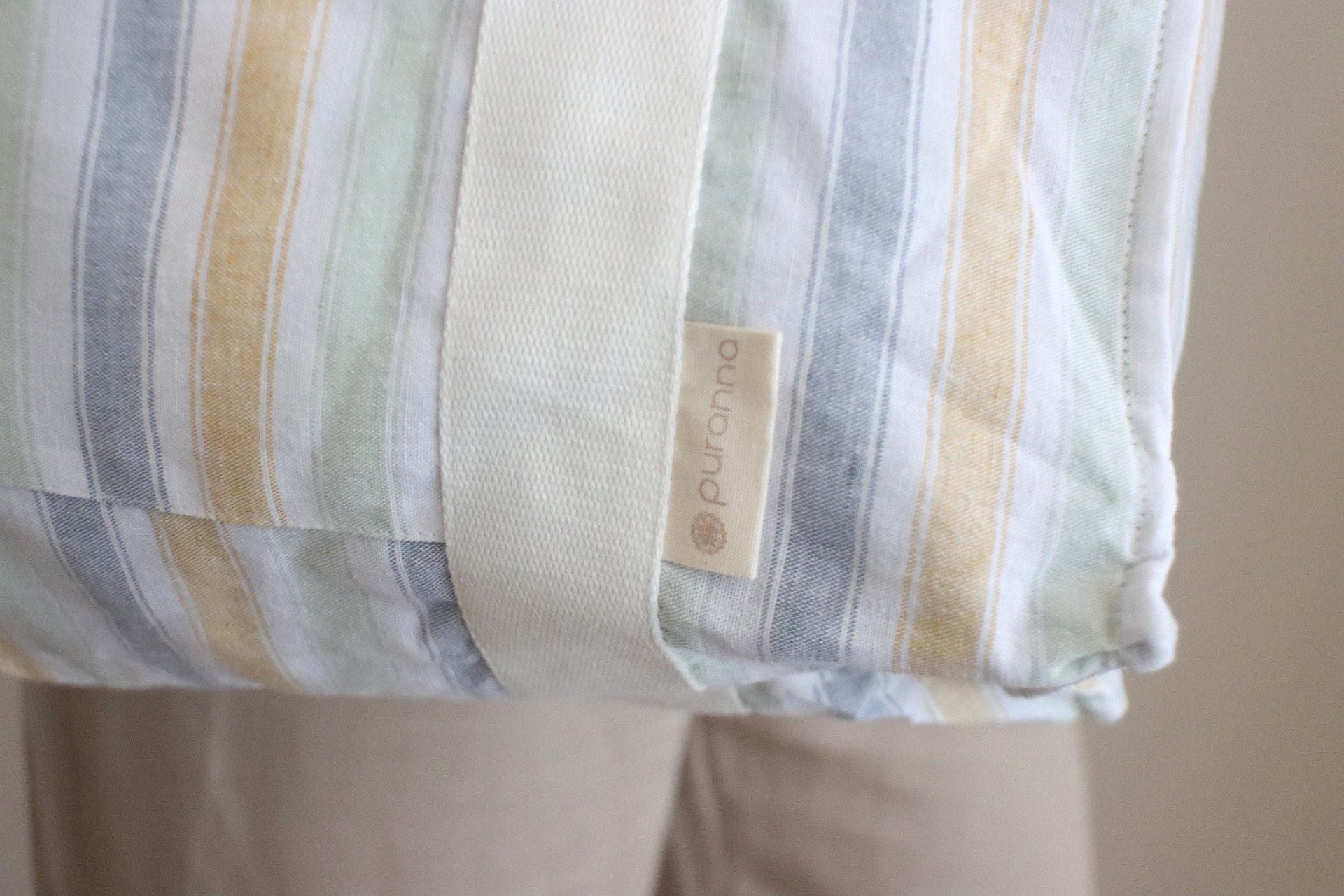 Almofada com capa de tecido listrado e etiqueta 'Puro Lino'