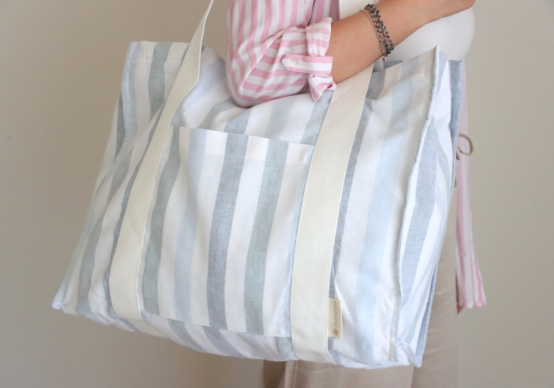 Mala de tecido riscada em azul claro e branco com alças brancas