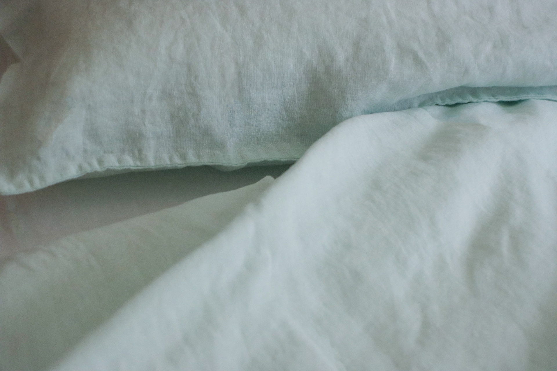 almofada e edredão verde claro em tecido macio com textura enrugada
