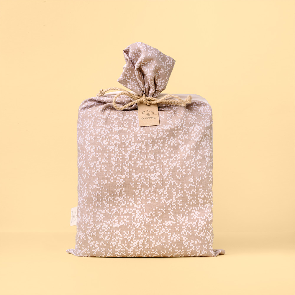 Saco de pano bege com padrão branco e cordão de sisal