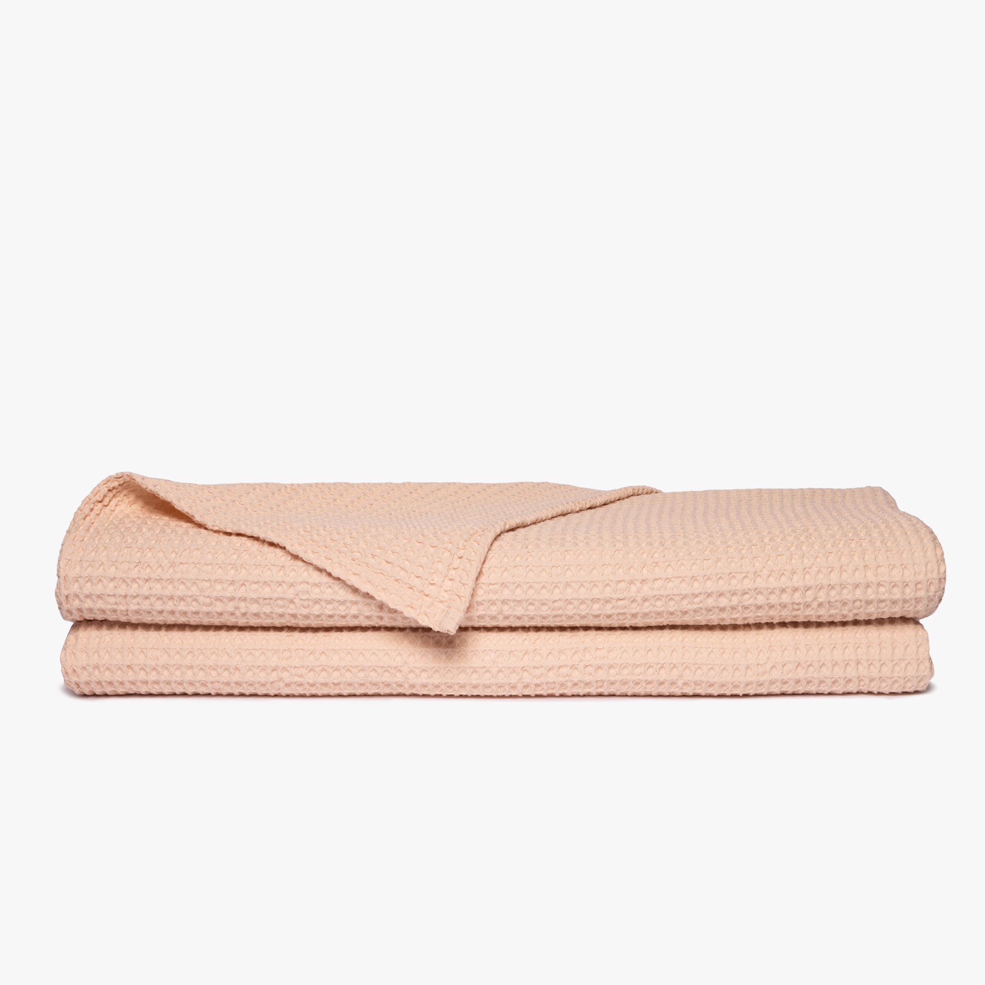 Cobertor bege claro com textura em padrão de colmeia sobre fundo branco