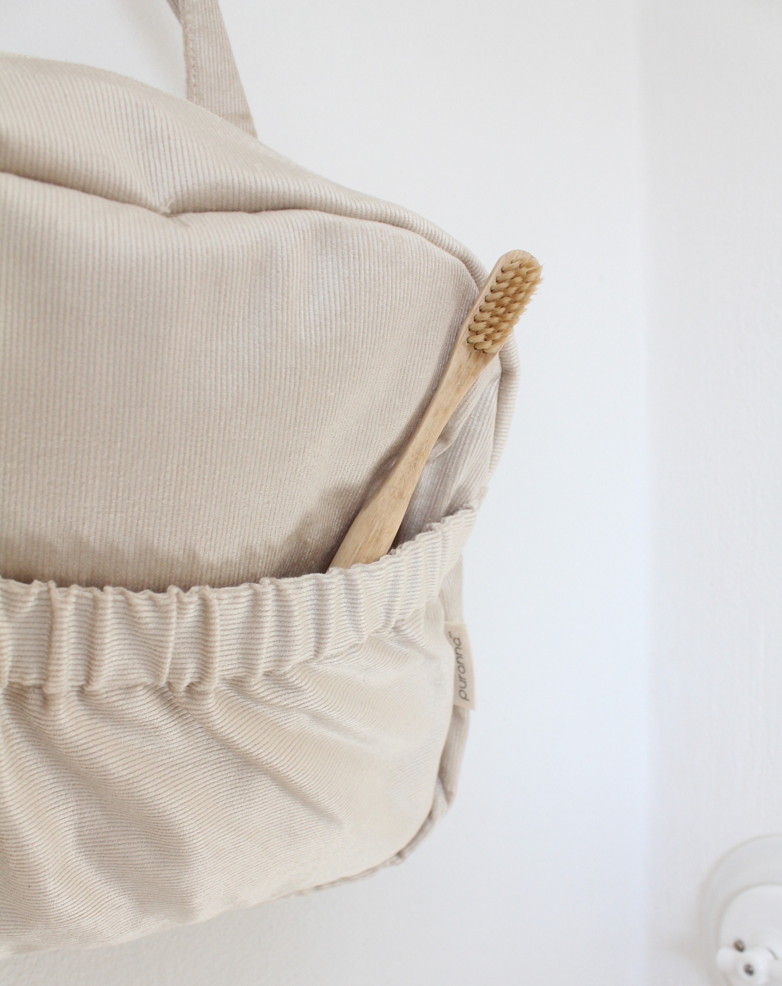 Mochila bege com bolso elástico e escova de dentes de madeira