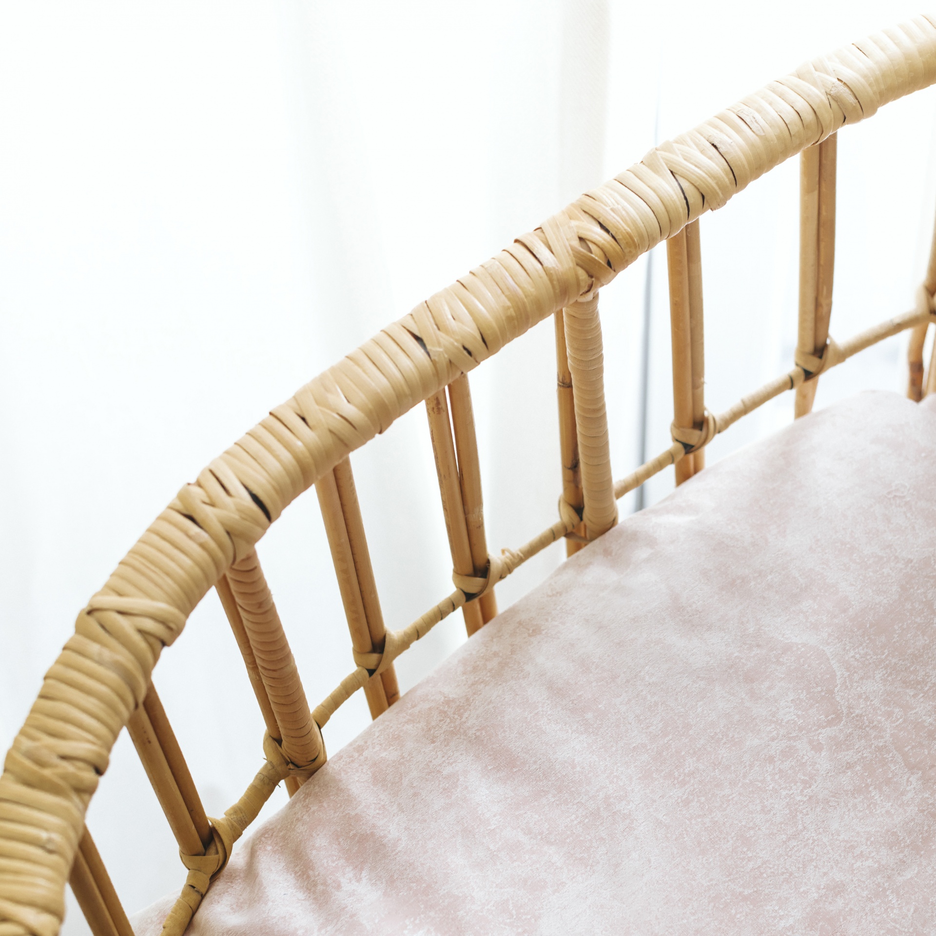 Detalhe de cadeira com estrutura de rattan e almofada bege