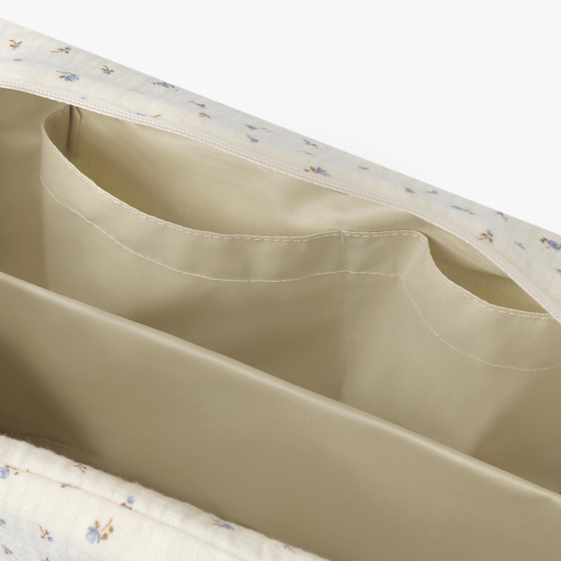 Interior de mala com compartimentos e forro bege com padrão floral exterior