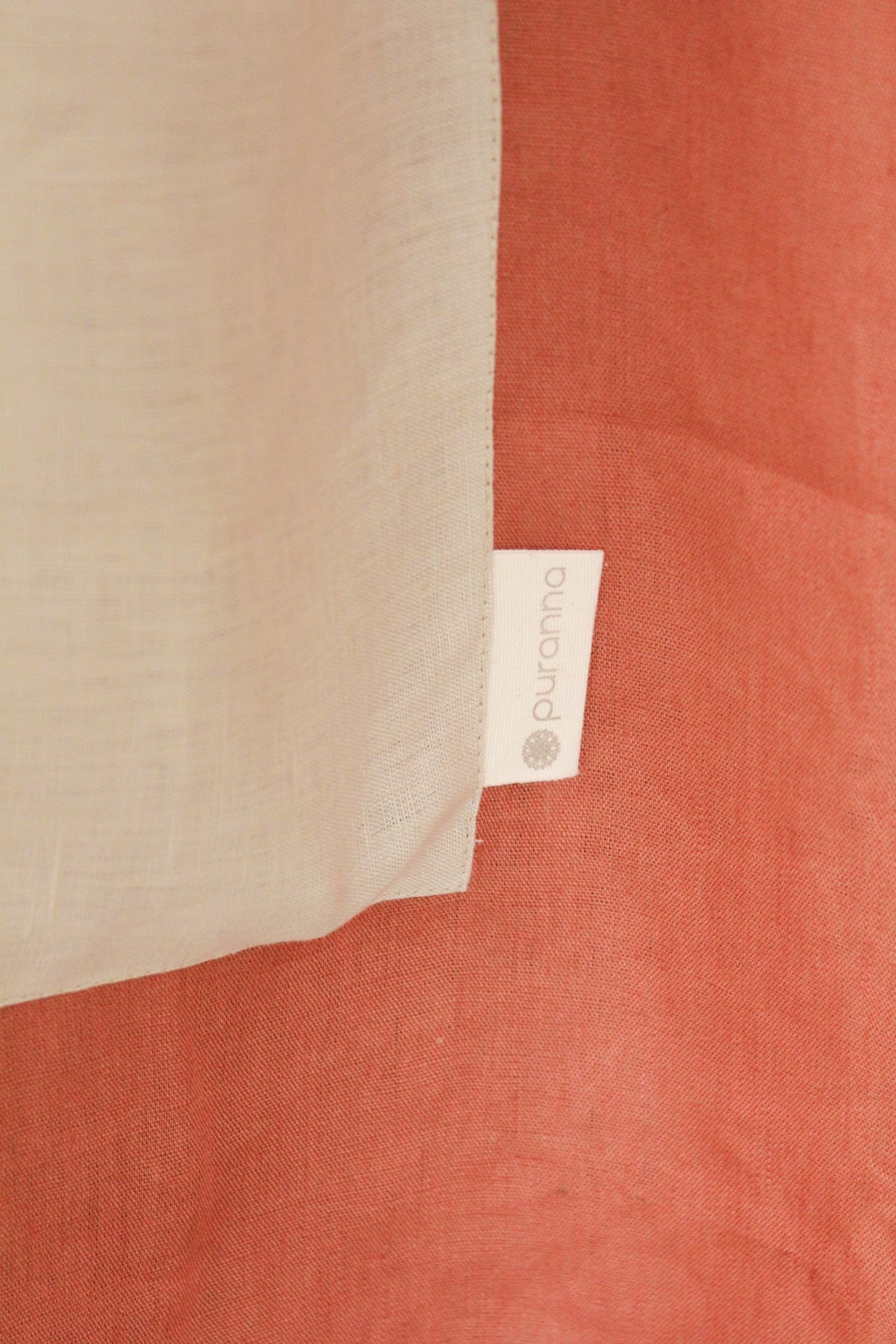 tecidos branco e terracota com etiqueta Puranna