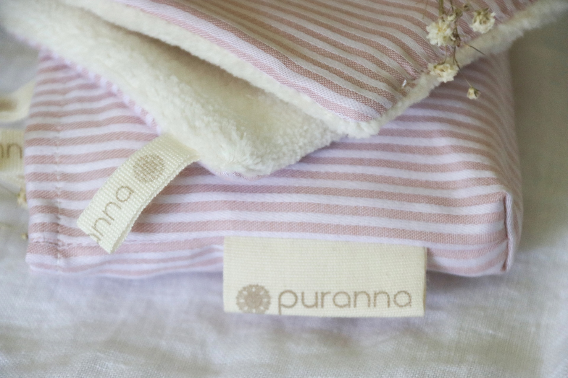 Tecidos listrados rosa e branco com etiquetas puranna e pura