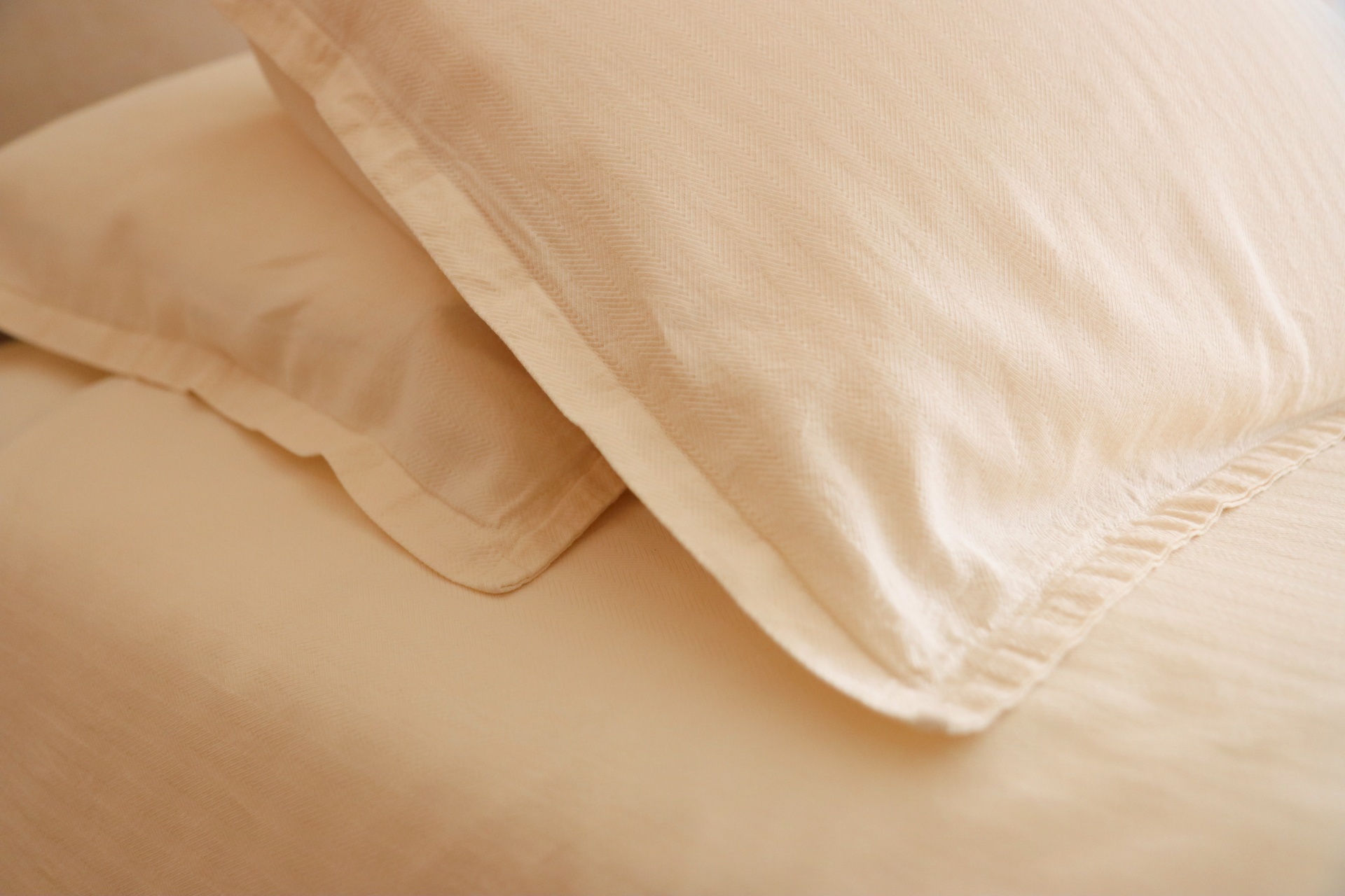 Travesseiros e lençóis de cama bege com textura lisa