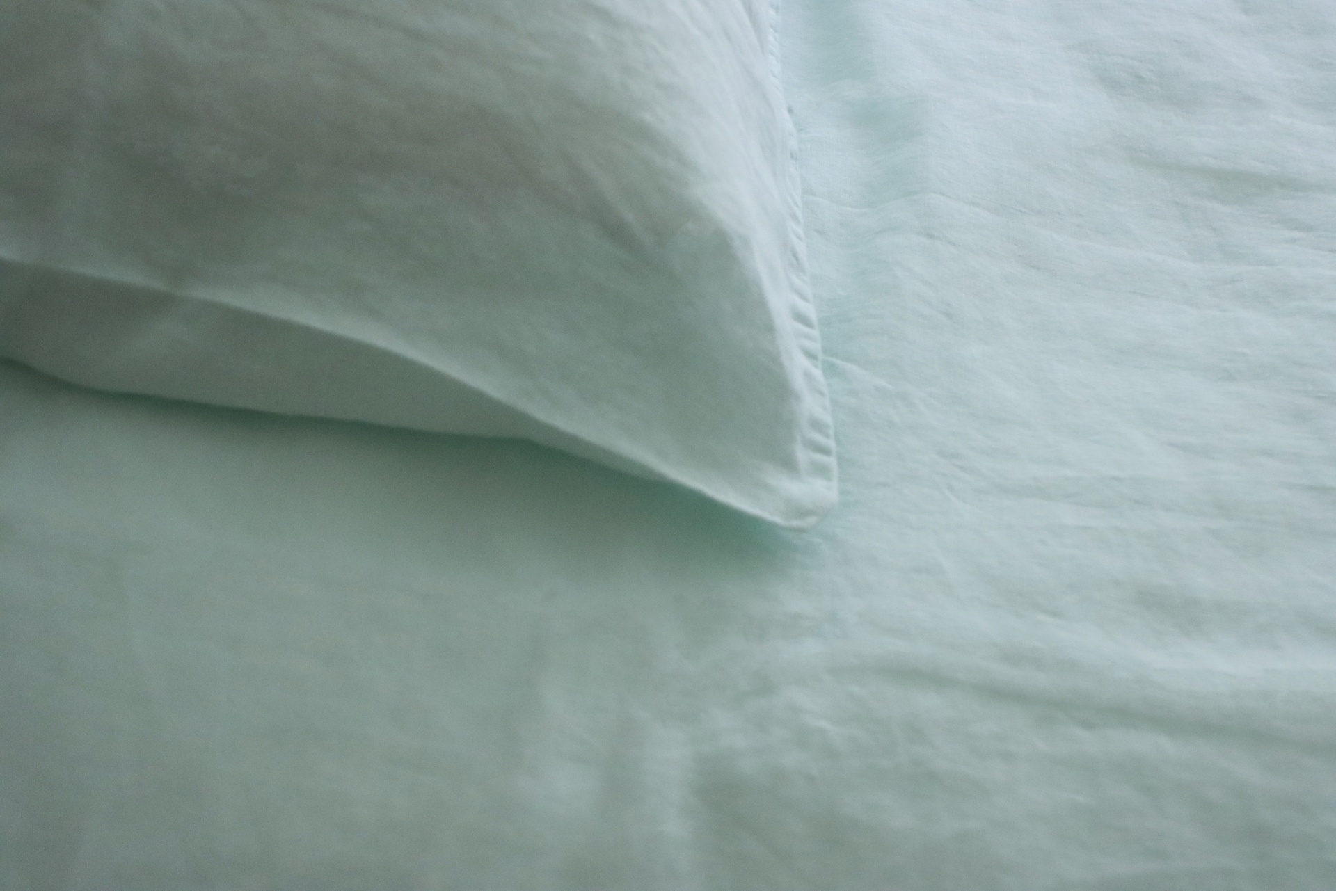 Lençol e fronha verde claro sobre cama