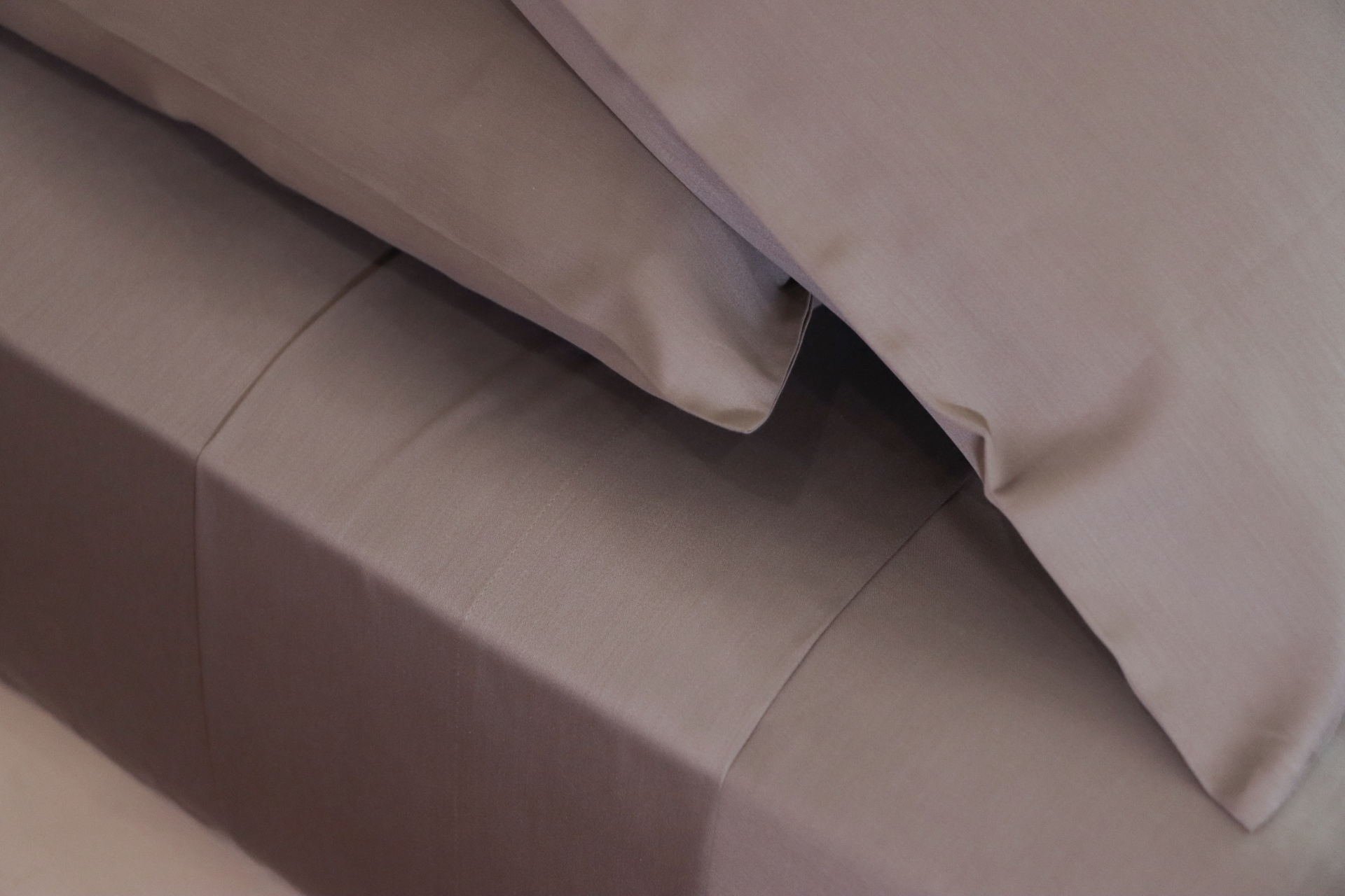 Colcha e fronhas cinzentas lisas sobre cama