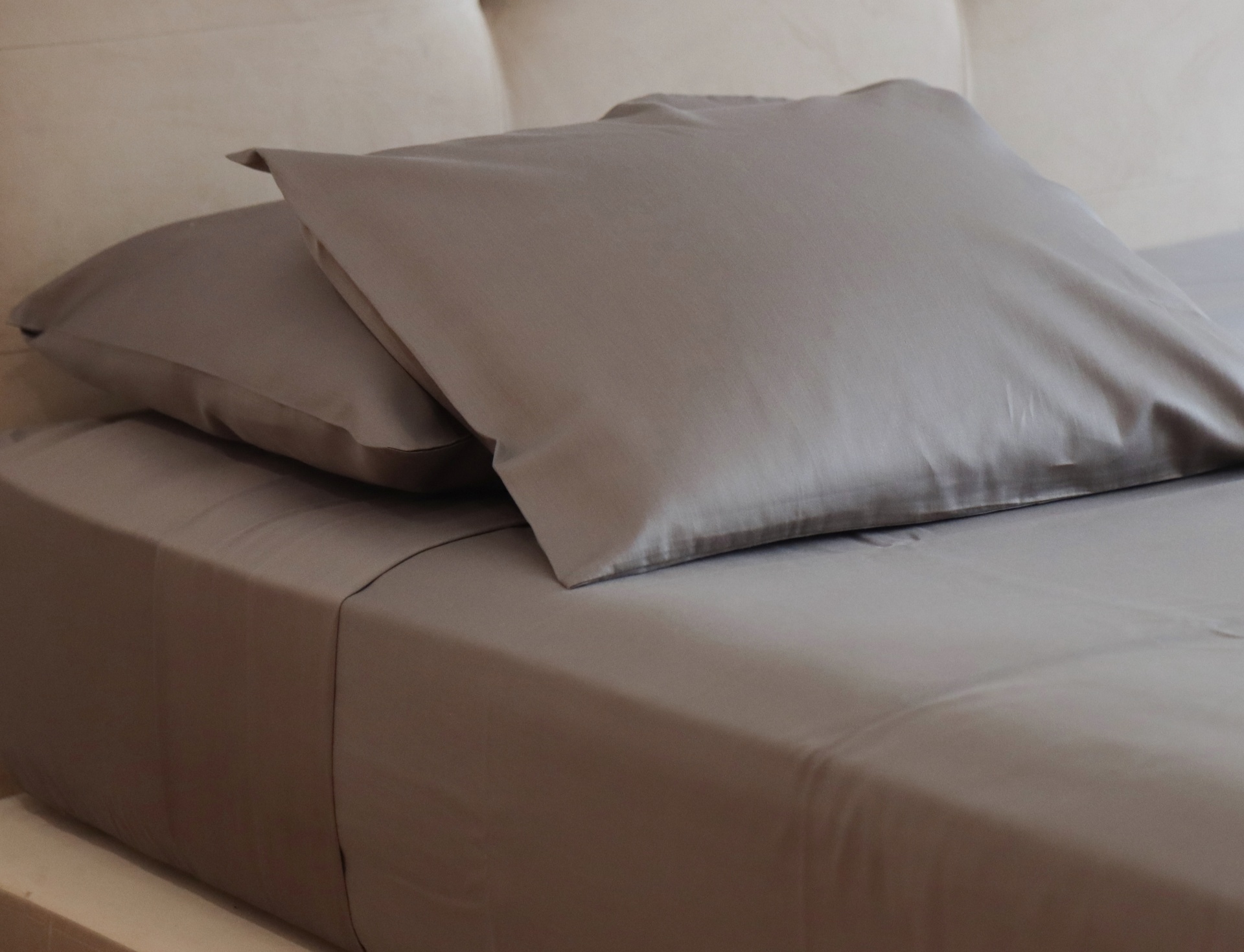 conjunto de roupa de cama cinzenta com fronhas e lençol ajustado