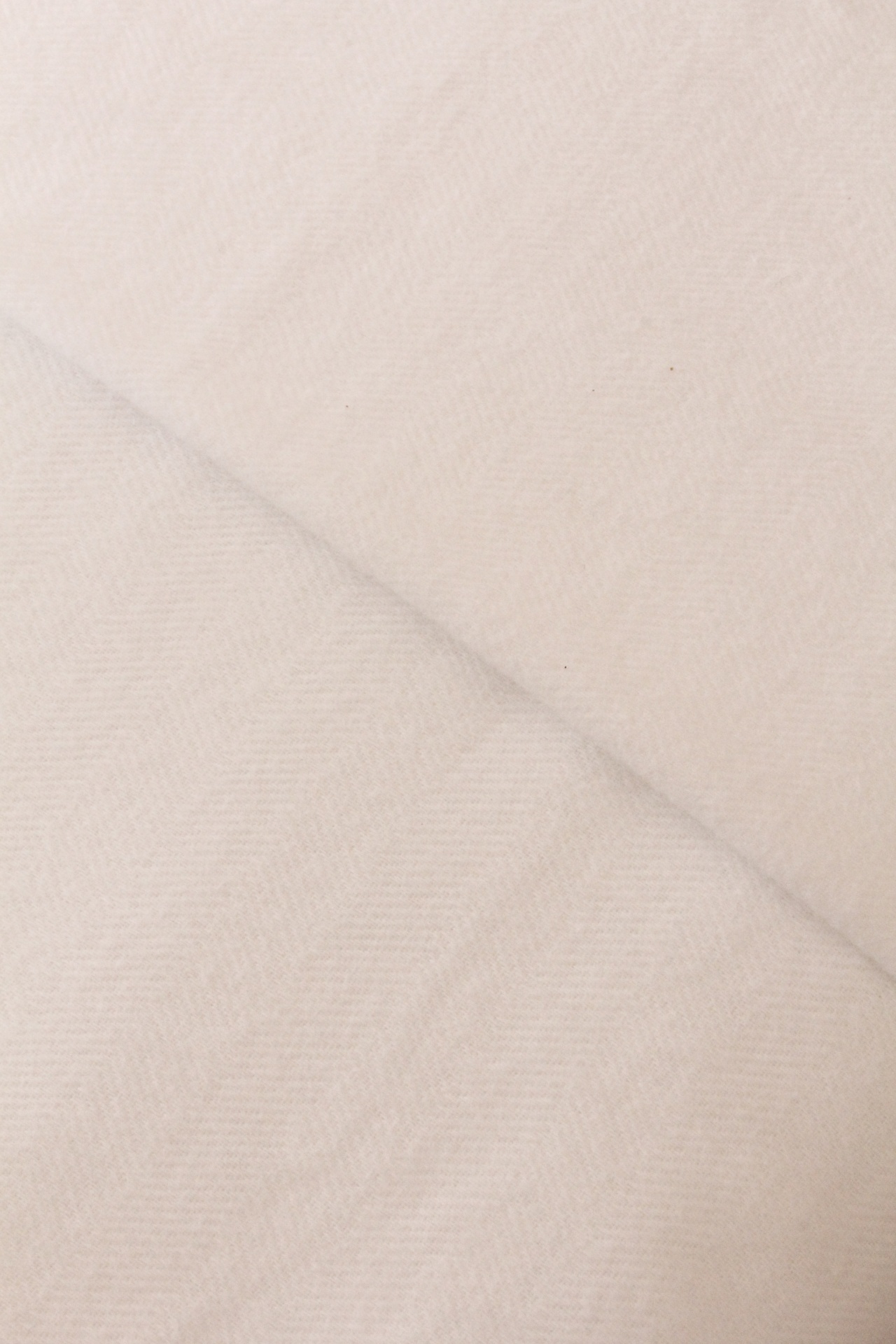 Tecido bege claro com padrão espinha de peixe sutil