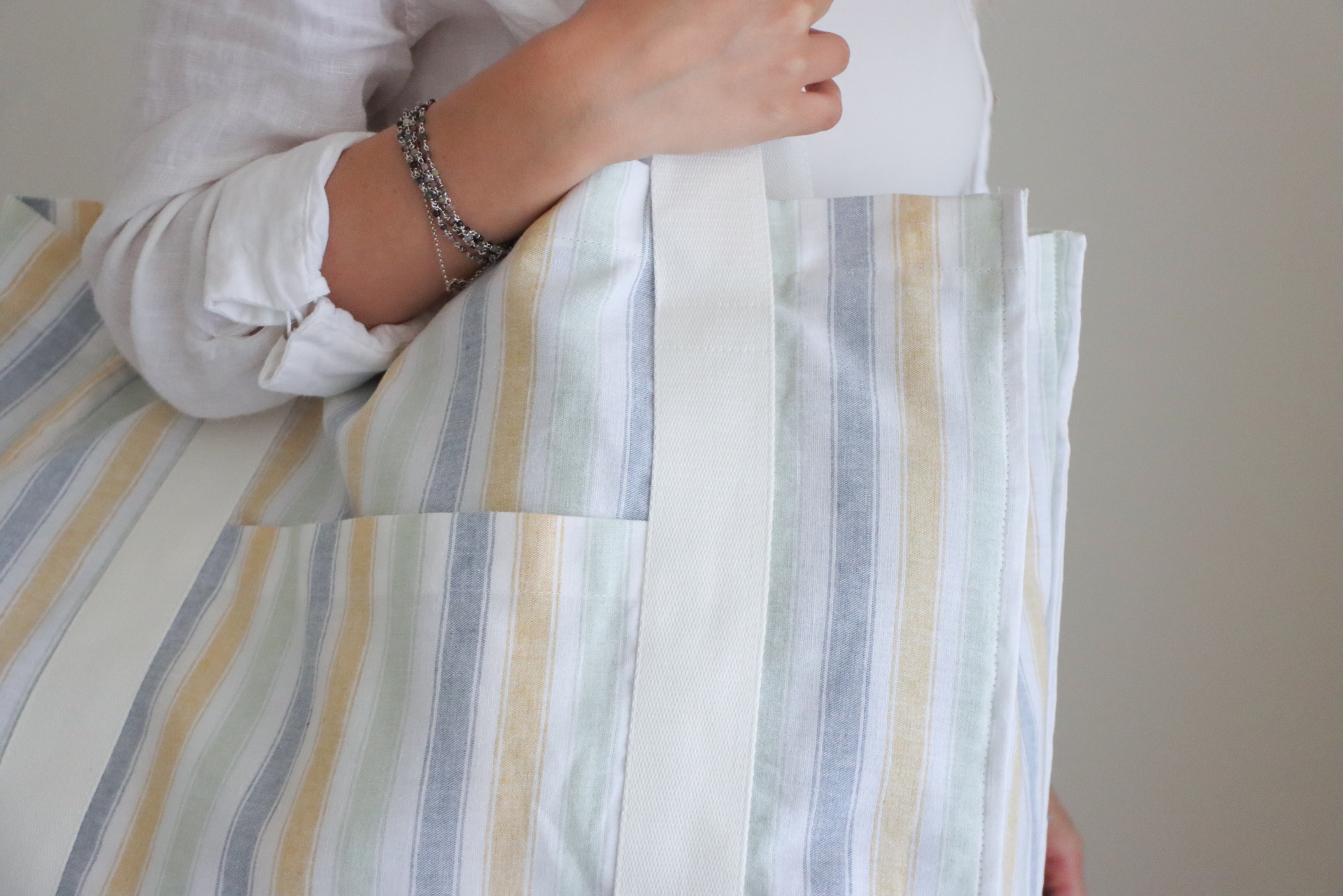 Sacola riscada pastel com alça branca ao ombro