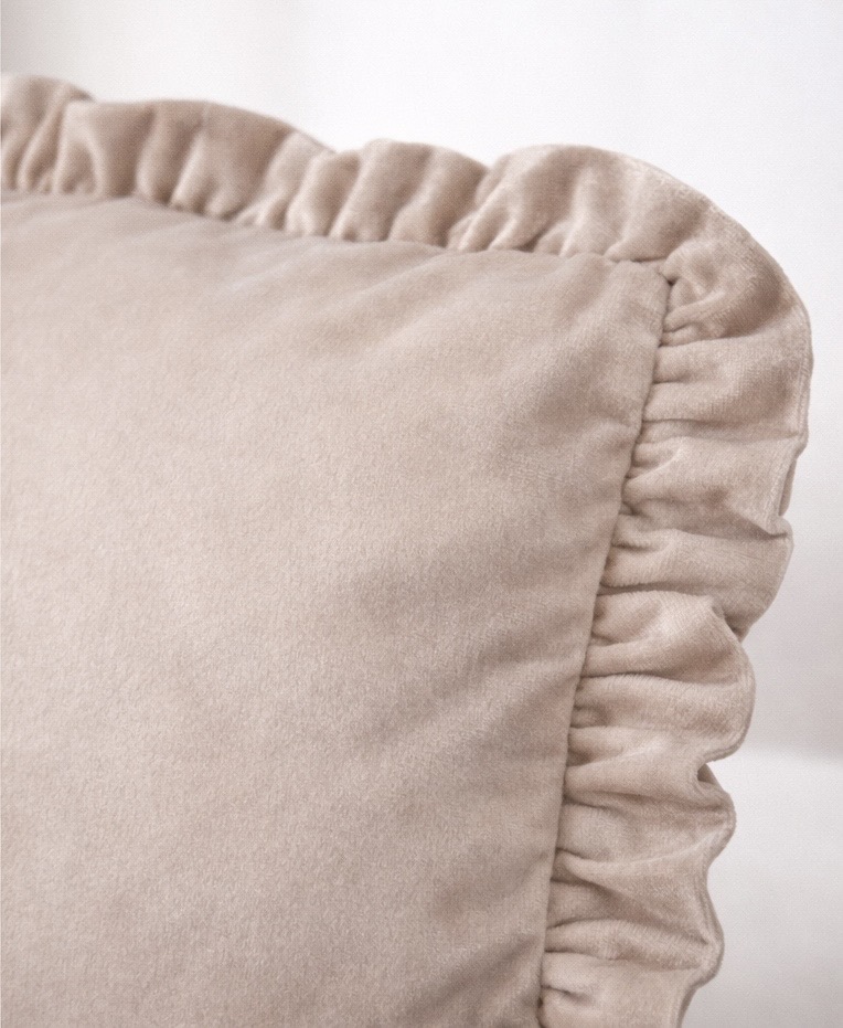 Almofada bege com bordas franzidas e tecido macio