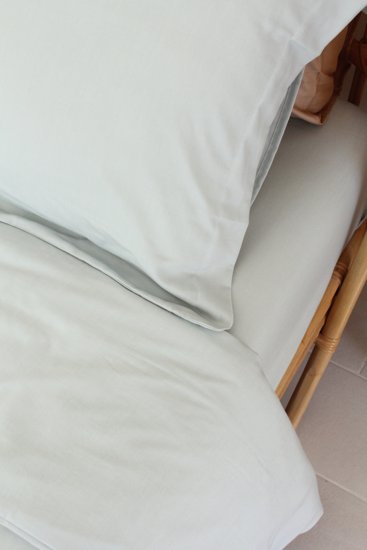 Conjunto de roupa de cama branco liso em cama de madeira clara