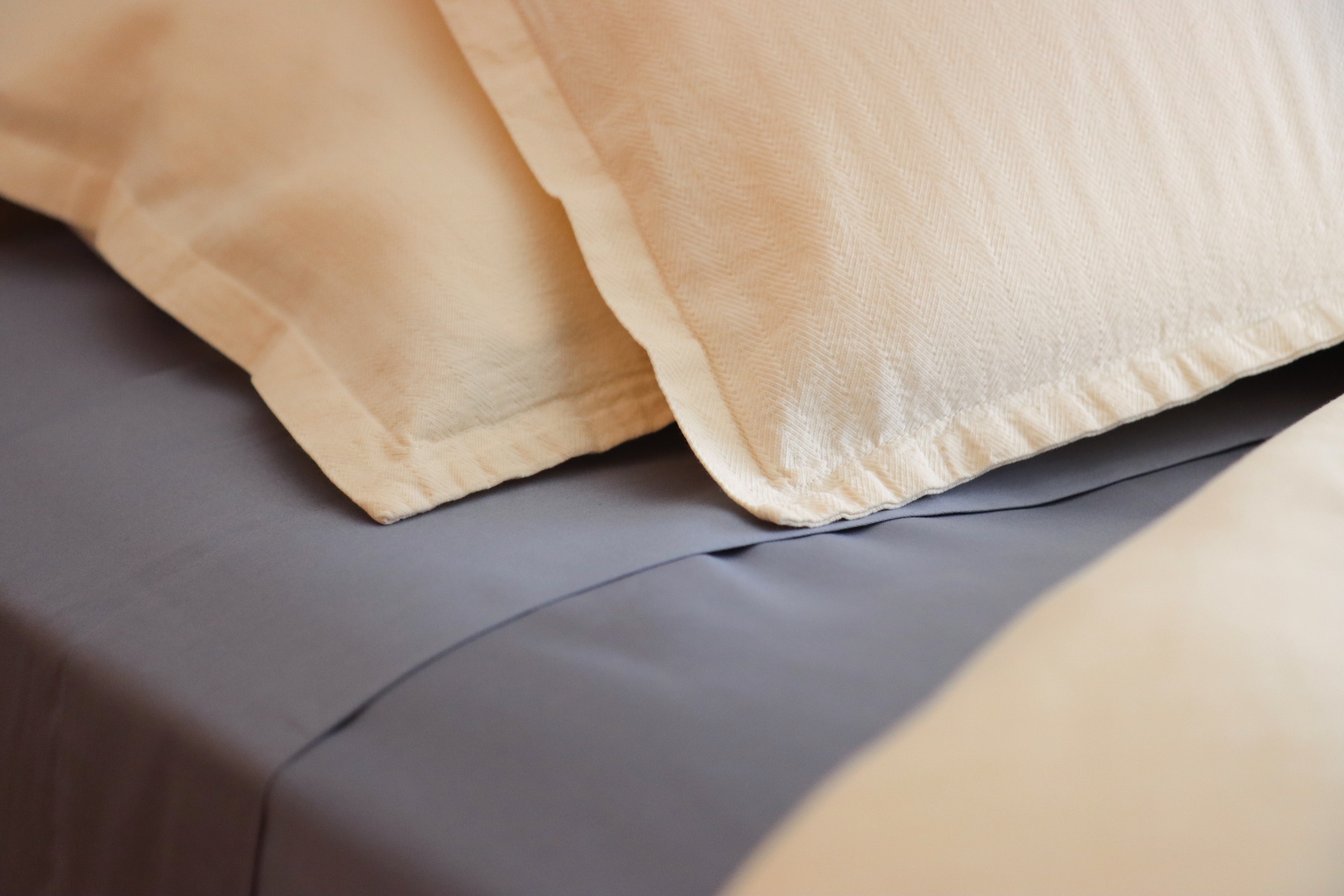 Travesseiros com fronhas amarelas claras sobre lençol cinza