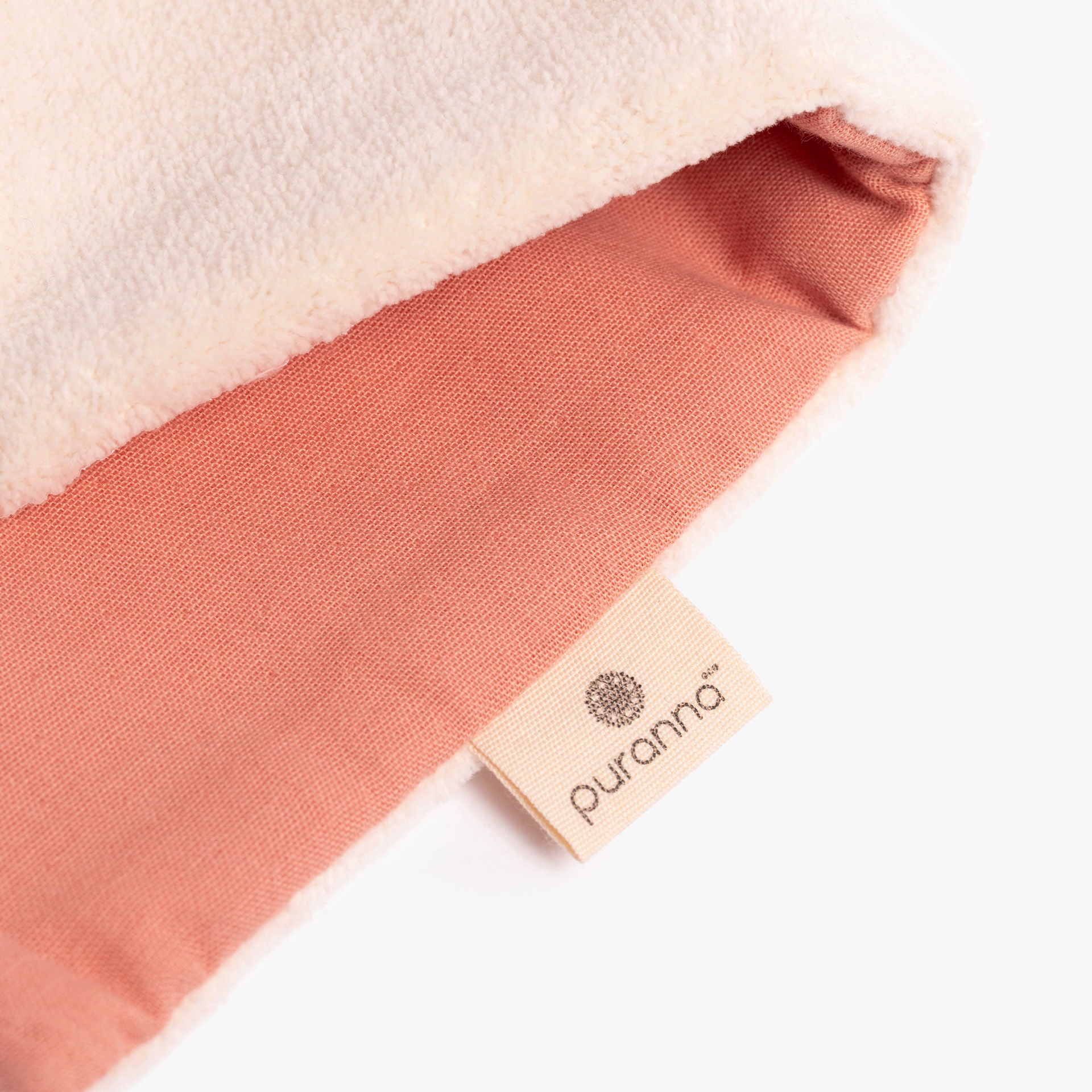 Detalhe de tecido salmão e creme com etiqueta Puranna